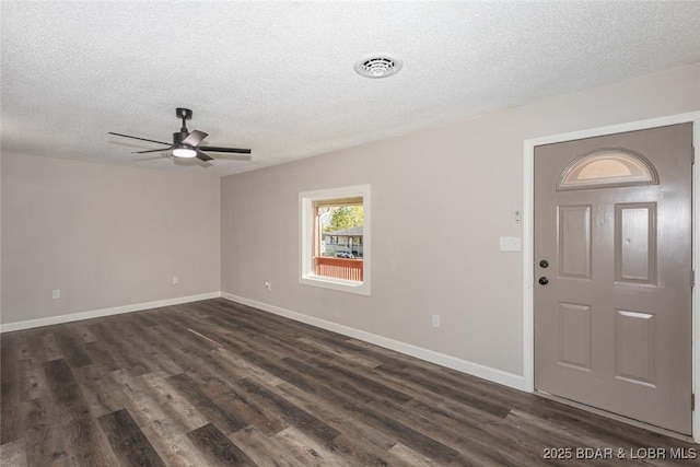 entryway with ceiling fan, a textured ceiling, and dark wood-type flooring