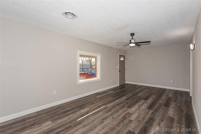 empty room featuring ceiling fan, dark wood-type flooring, and a textured ceiling