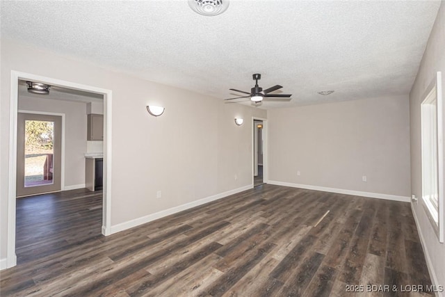 empty room featuring ceiling fan, dark wood-type flooring, and a textured ceiling