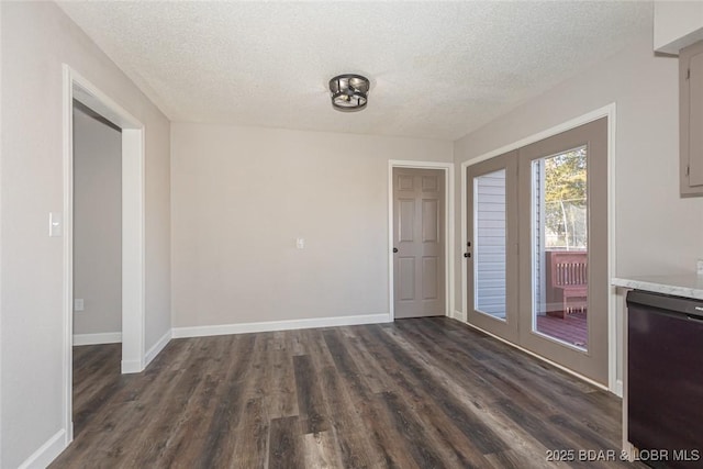 unfurnished room with dark wood-type flooring and a textured ceiling