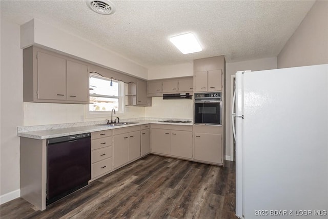 kitchen featuring dark hardwood / wood-style floors, sink, black appliances, and a textured ceiling