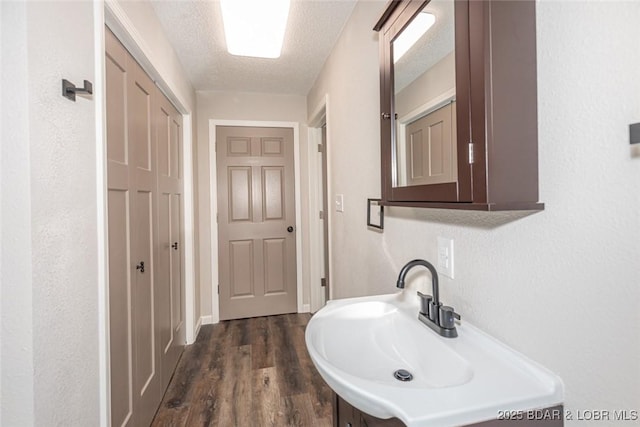 bathroom with sink, a textured ceiling, and hardwood / wood-style flooring