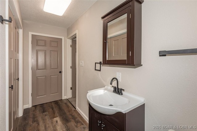 bathroom featuring vanity, wood-type flooring, and a textured ceiling