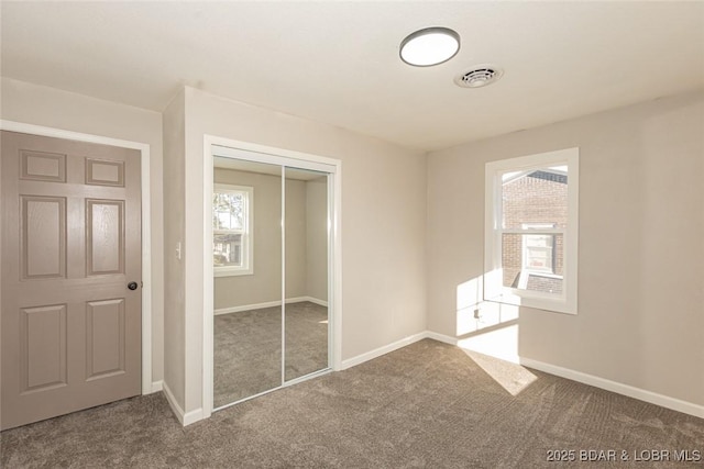 unfurnished bedroom with carpet flooring and a closet