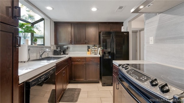 kitchen featuring backsplash, black appliances, sink, light tile patterned floors, and range hood