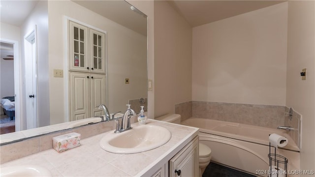 bathroom with a bathtub, vanity, and toilet