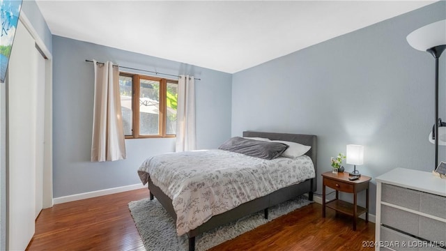 bedroom with dark wood-type flooring