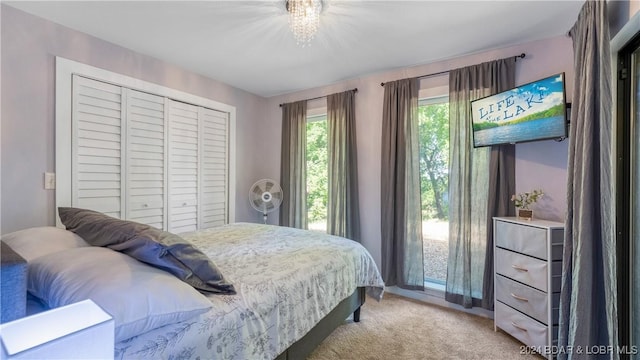 carpeted bedroom featuring a chandelier and a closet