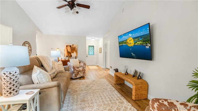 living room with ceiling fan, light hardwood / wood-style floors, and lofted ceiling