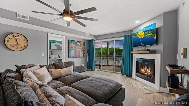 living room with ceiling fan and light hardwood / wood-style flooring