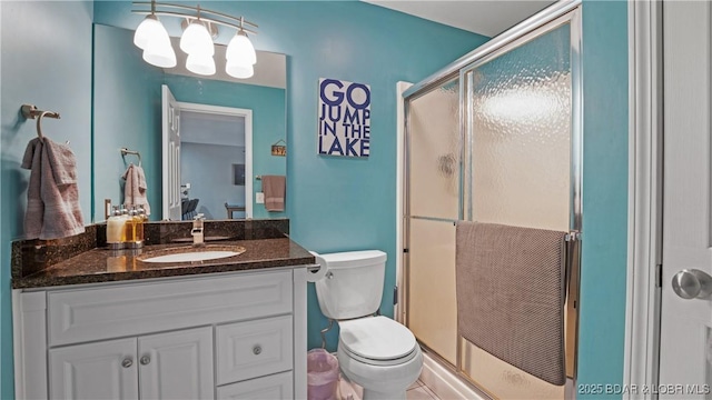 bathroom featuring walk in shower, vanity, and toilet