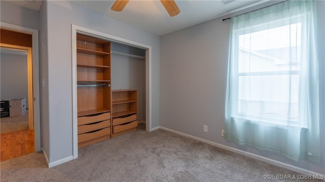 unfurnished bedroom featuring light colored carpet, a closet, and ceiling fan