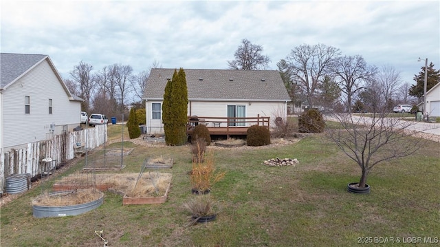 back of property featuring a deck and a lawn