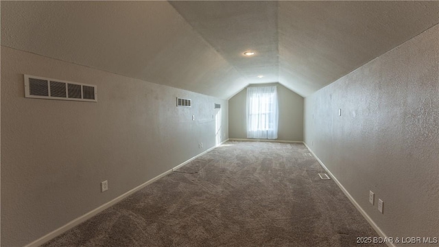 bonus room with a textured ceiling, carpet, and lofted ceiling