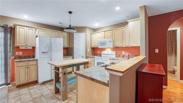 kitchen with hanging light fixtures and white appliances