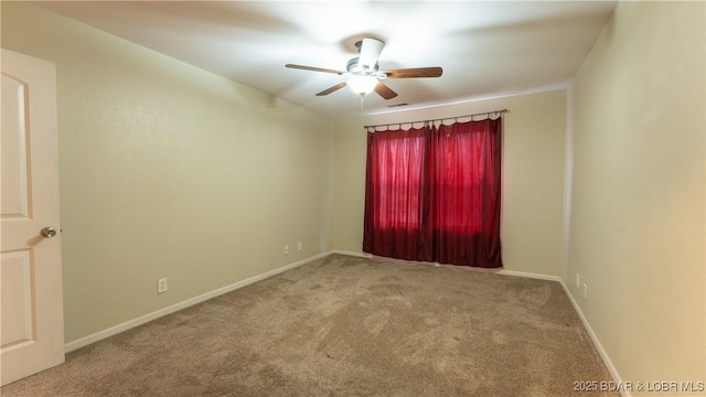 carpeted spare room featuring ceiling fan