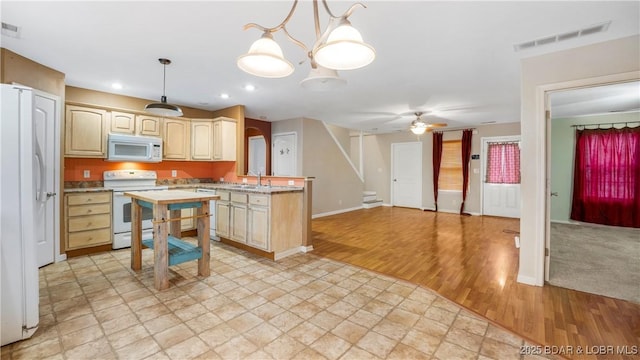 kitchen featuring light brown cabinets, white appliances, ceiling fan with notable chandelier, sink, and hanging light fixtures