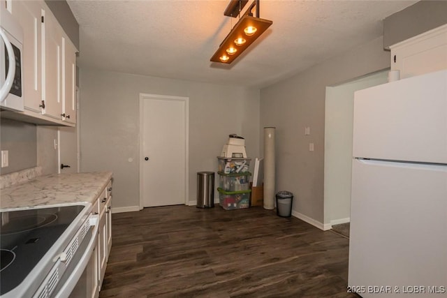 kitchen with white cabinets, dark hardwood / wood-style floors, and white appliances