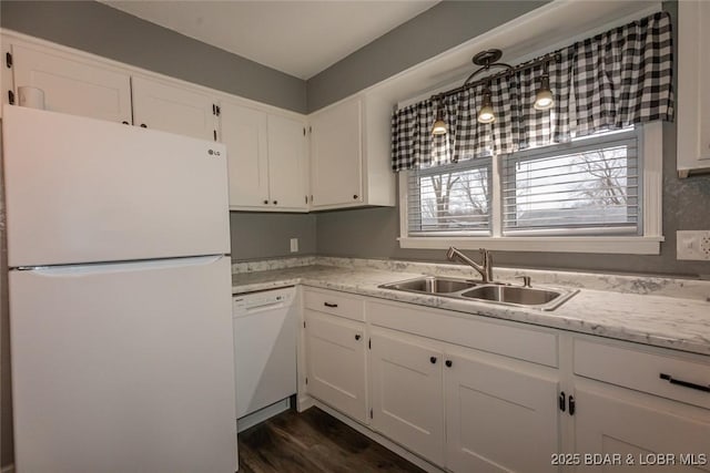 kitchen with white appliances, decorative light fixtures, white cabinetry, and sink