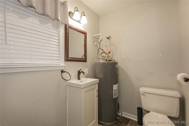 bathroom featuring vanity, electric water heater, and toilet