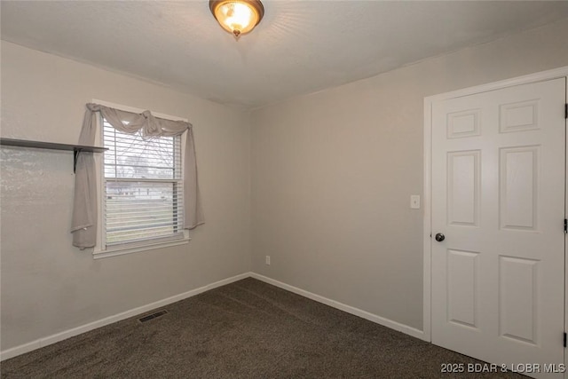 empty room with dark colored carpet