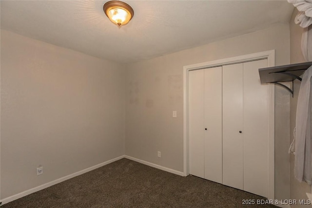 unfurnished bedroom with a closet and dark carpet