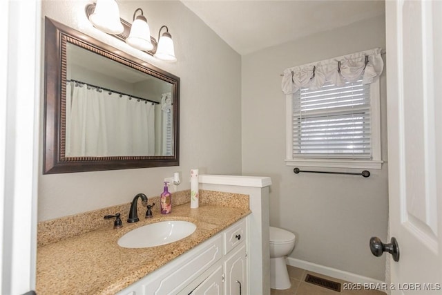 bathroom featuring toilet, vanity, and tile patterned floors