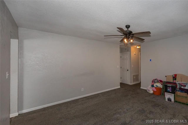 recreation room with ceiling fan, dark carpet, and a textured ceiling