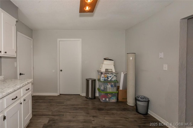 kitchen featuring white cabinets, dark hardwood / wood-style flooring, and light stone countertops