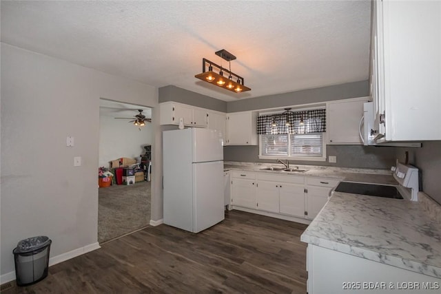 kitchen with white appliances, sink, hanging light fixtures, dark hardwood / wood-style flooring, and white cabinetry