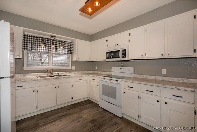 kitchen with dark hardwood / wood-style flooring, sink, white cabinets, and white appliances