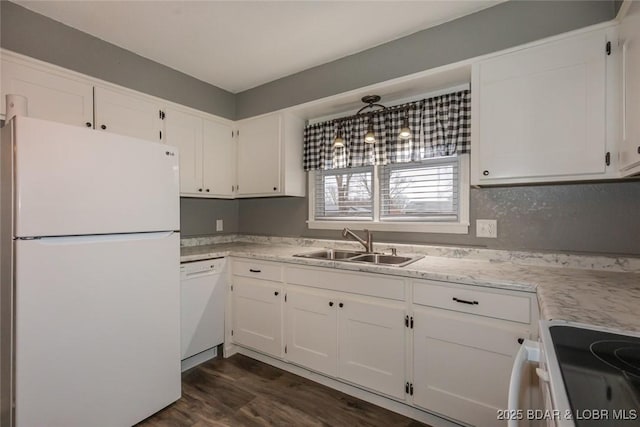 kitchen featuring white appliances, dark wood-type flooring, sink, white cabinetry, and hanging light fixtures