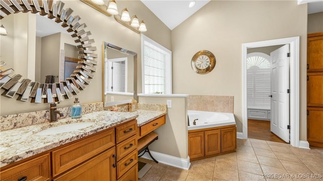 bathroom with tile patterned flooring, vanity, a bathing tub, and vaulted ceiling