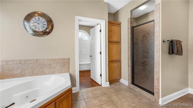 bathroom with separate shower and tub and tile patterned floors