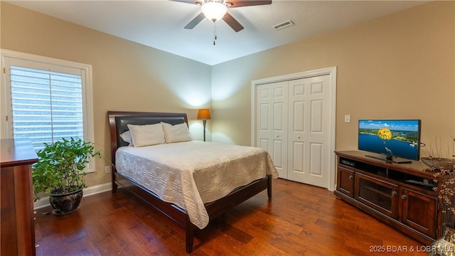 bedroom featuring dark wood-type flooring, ceiling fan, and a closet