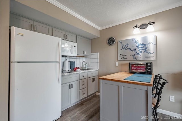 kitchen featuring butcher block counters, dark hardwood / wood-style flooring, a textured ceiling, white appliances, and decorative backsplash