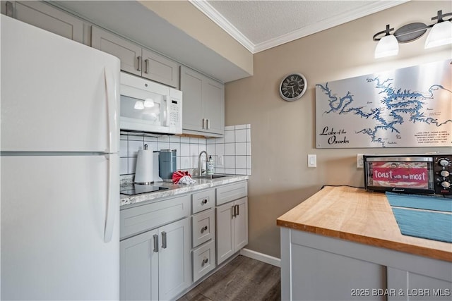 kitchen featuring white appliances, crown molding, sink, a textured ceiling, and butcher block counters