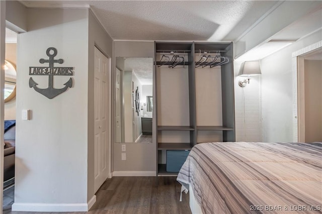 bedroom featuring dark hardwood / wood-style flooring, a textured ceiling, and a closet