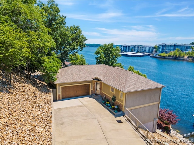 single story home featuring a garage and a water view