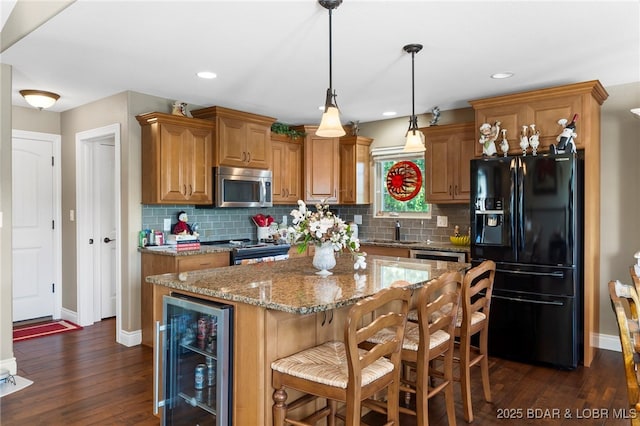 kitchen featuring stove, black refrigerator with ice dispenser, wine cooler, light stone countertops, and a kitchen island