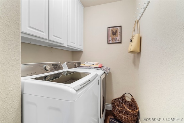 laundry area featuring washer and clothes dryer and cabinets