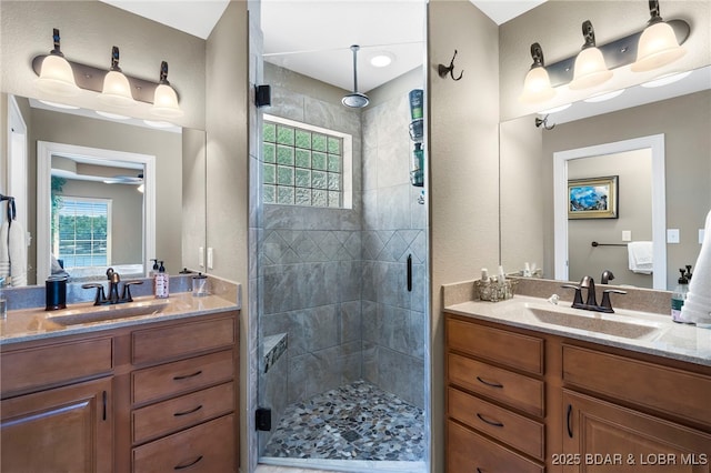 bathroom with vanity, a healthy amount of sunlight, and a shower with door