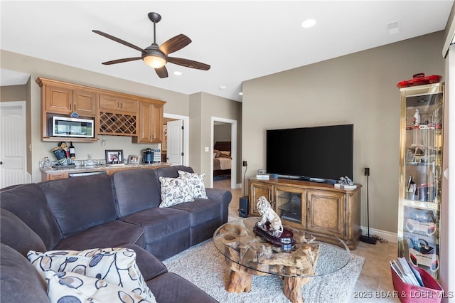 living room with bar, light tile patterned floors, and ceiling fan