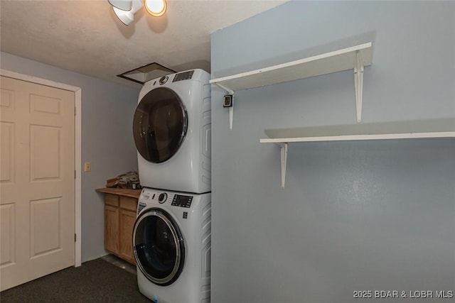 washroom with cabinets and stacked washing maching and dryer