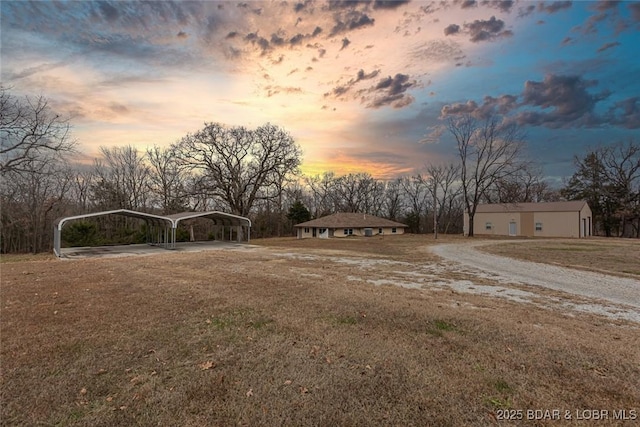 yard at dusk featuring a carport