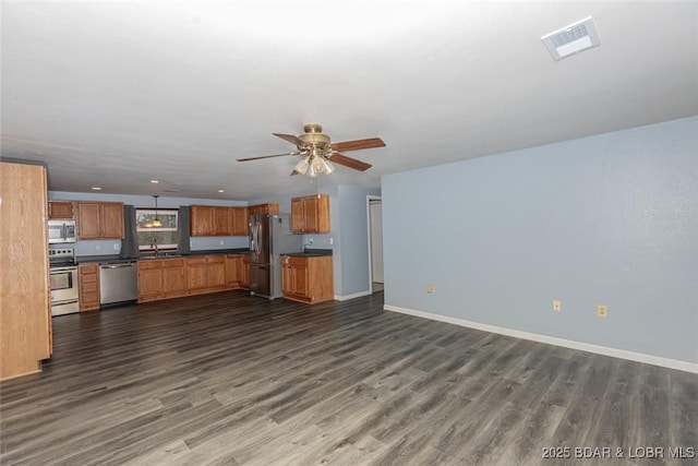 unfurnished living room with ceiling fan, sink, and dark wood-type flooring