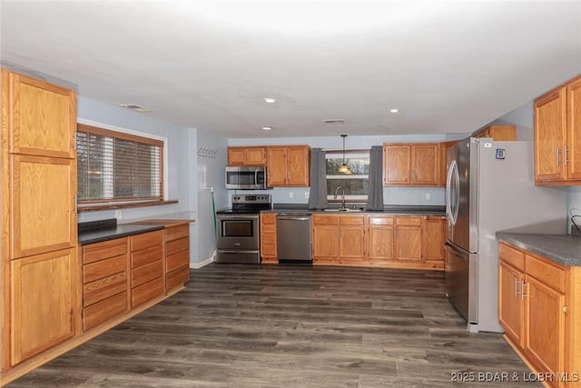 kitchen with pendant lighting, sink, appliances with stainless steel finishes, and dark wood-type flooring