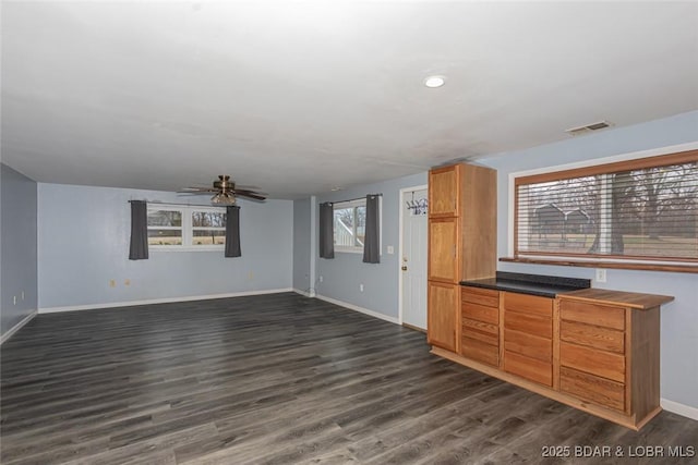 unfurnished living room featuring ceiling fan and dark hardwood / wood-style floors