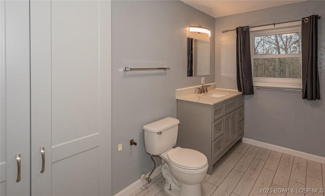 bathroom with hardwood / wood-style flooring, vanity, and toilet