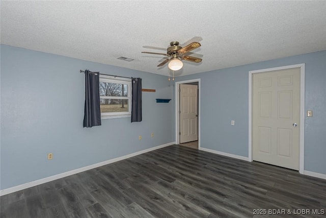 empty room with a textured ceiling, dark hardwood / wood-style floors, and ceiling fan